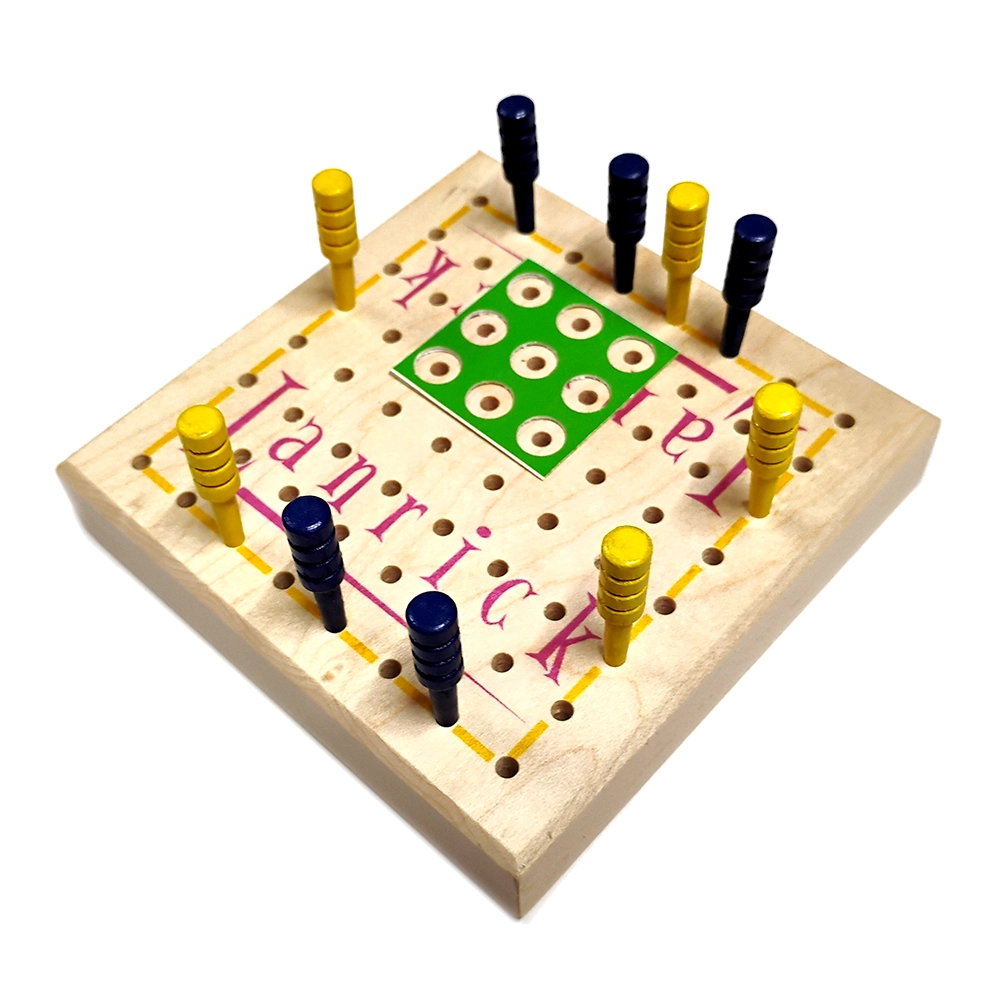 A wooden peg solitaire game board with a light natural wood base, yellow and navy pegs, and a green scoring area, photographed on a clean white background.