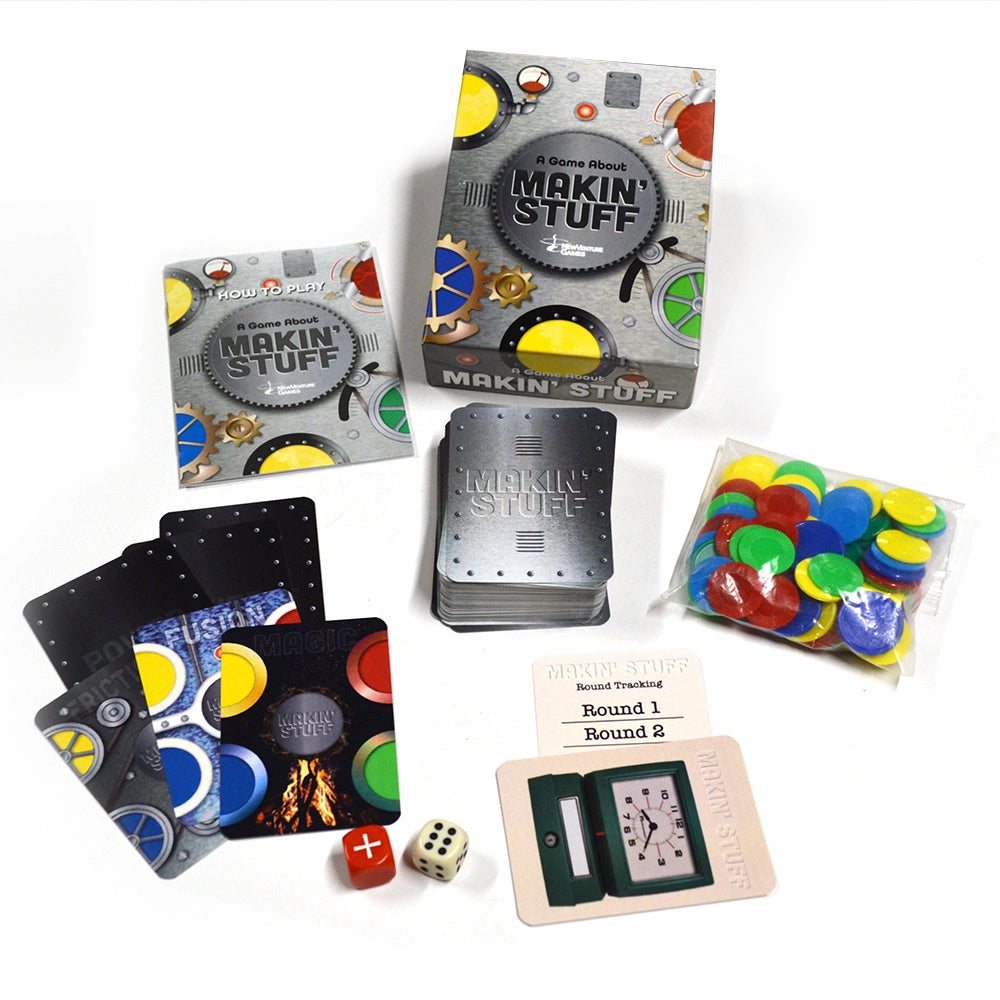 Makin' Stuff board game set displayed on a white background, including the main box, smaller packaging box, deck of cards, playing cards, dice, and a bag of colorful round tokens.